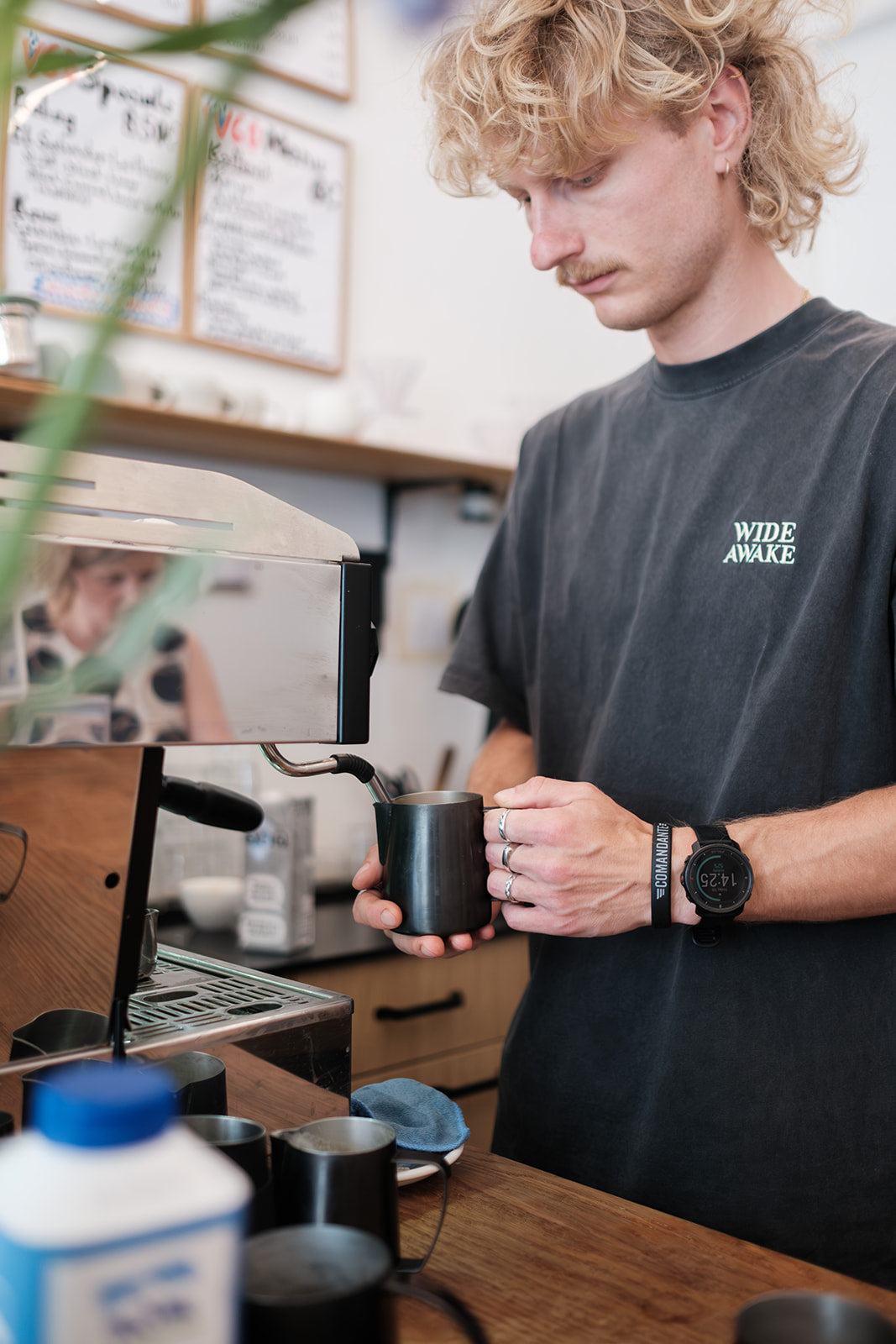 Barista schäumt Milch an der Siebträgermaschine im Café kaffemik in Wien